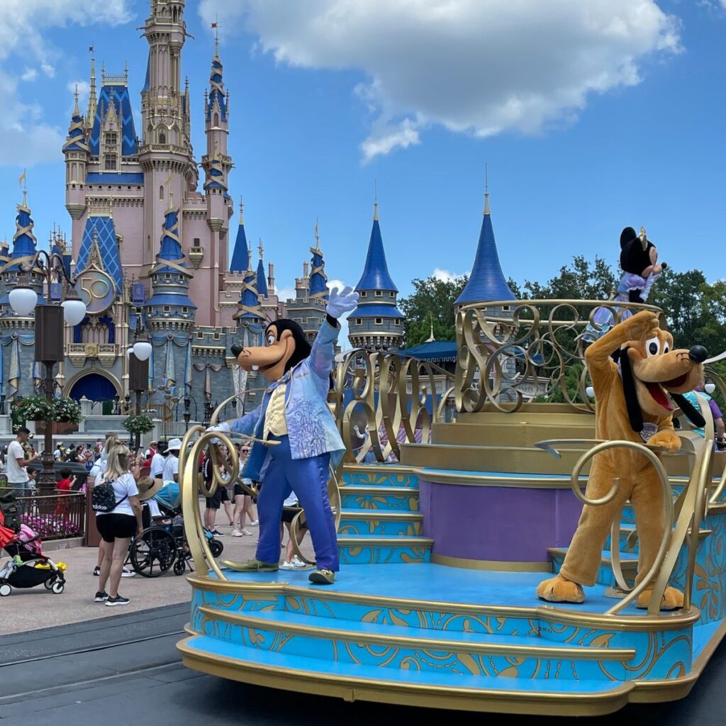 parade at magic kingdom in Disney World - goofy and pluto wave to the crowds