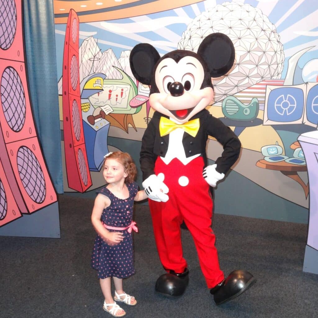 child posing with Mickey Mouse at Epcot