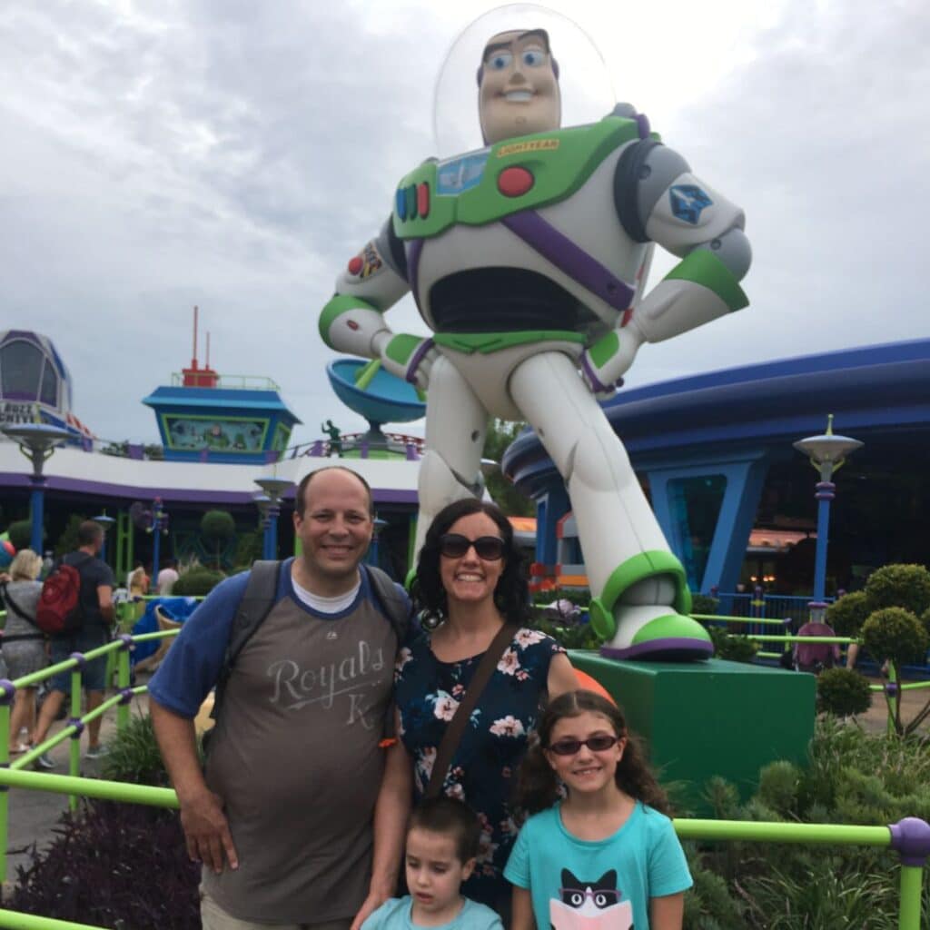family posing with Buzz Lightyear statue
